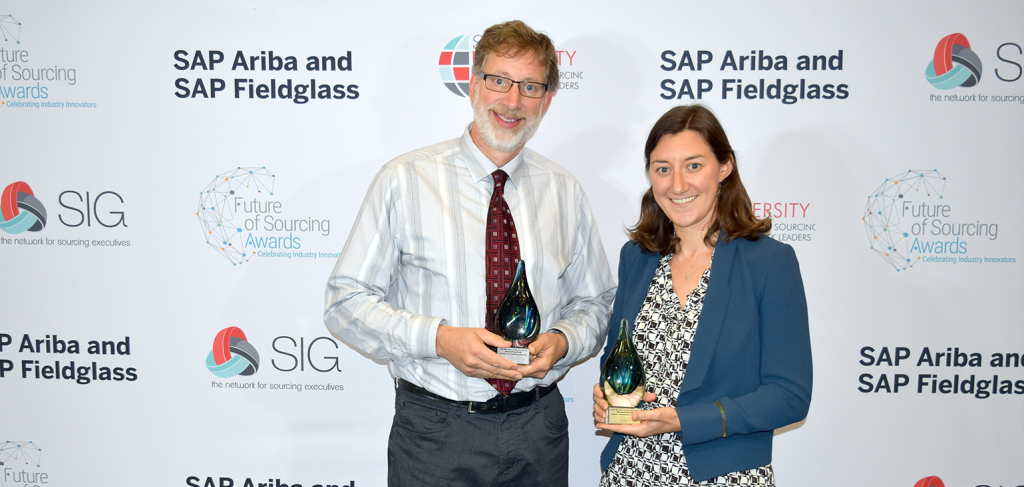 Two people in business attire smile and hold glass awards while standing in front of a backdrop featuring SAP Ariba, SAP Fieldglass, SIG, and Future of Sourcing Awards logos. Sourcing, Procurement, 3rd Party Risk